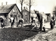Op de voorgrond Jan Veldhuizen tijdens asfalteringswerkzaamheden.